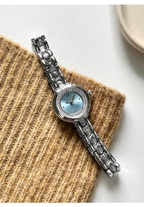 Detail of silver GEDI quartz watch with sky blue dial and rhinestone bezel on brown knit