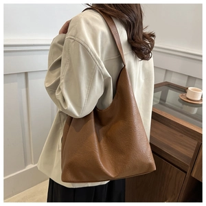 Detailed close-up of brown vintage hobo tote bag with pleated texture and wide strap