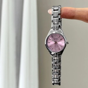 Elegant women quartz watch with pink sunray dial and silver metal strap hanging on finger