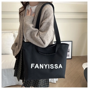 Detail of black canvas tote bag with FANYISSA print and durable double handles