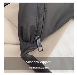 Macro shot of smooth black metal zipper head and durable fabric of the crossbody bag