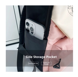 Detail of color-block backpack side pocket featuring storage for a smartphone