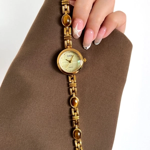 Luxurious gold quartz watch for women with amber stone links and a green brushed dial