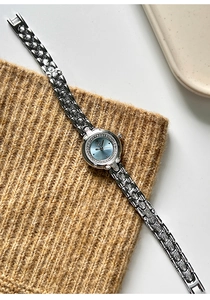 Detail of light blue dial ladies watch with sparkling stones and silver carved bracelet
