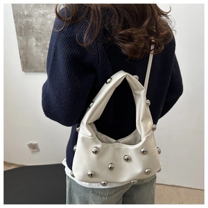 White leather shoulder bag with silver stud details shown on model from back view