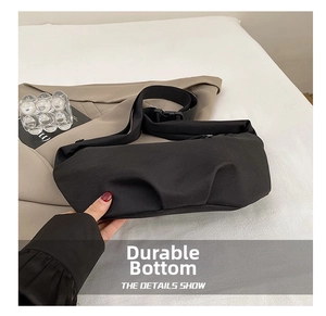 Detail of durable black nylon crossbody bag with adjustable wide strap and plastic buckle
