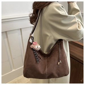 Detail of dark brown faux suede tote bag with stitched edges and sheep charm pendant