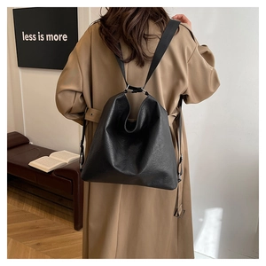 Sac fourre-tout en cuir souple noir sur modèle montrant la grande capacité et le style épuré