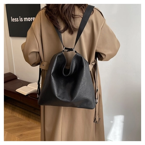 Detail of minimalist black large-capacity tote bag in pebble leather with nylon straps