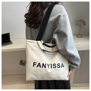Close-up of canvas tote bag featuring FANYISSA print and dual leather handles