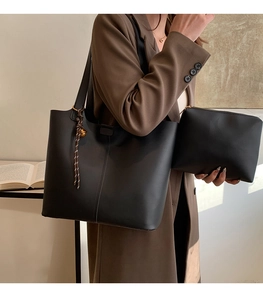 Vue détaillée du grand sac cabas noir mat avec pompon tressé et pochette assortie