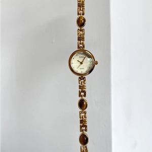 Elegant gold quartz watch for women featuring amber stones and a sleek metal chain strap