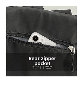 Detail of a black nylon backpack featuring a secure back anti-theft zipper pocket for a phone