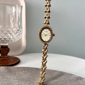 Elegant gold vintage chain watch for women featuring an oval dial and hollow metal strap