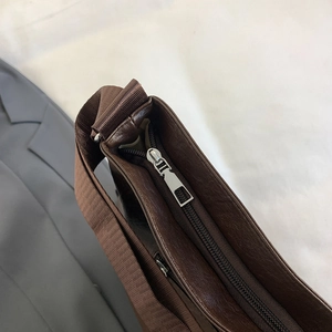 Large dark brown leather tote bag with silver zipper and durable nylon straps