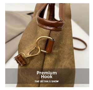 Dettaglio dei ganci dorati e finiture in pelle marrone sulla borsa a secchiello vintage