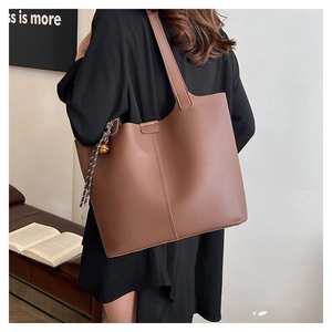Vue détaillée du grand sac cabas marron vintage avec pendentif cloche décoratif