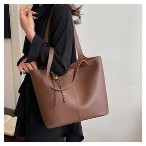 Détail d'un grand sac cabas marron montrant le décor tissé et la texture du cuir