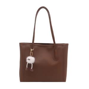 Brown leather tote bag for women with a cute white plush monster charm accessory