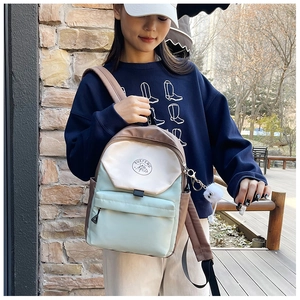 Detail of color-block school backpack with plush charm and circular mountain logo