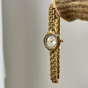 GEDI luxury gold women's watch with crystal bezel and engraved bracelet on a wrist