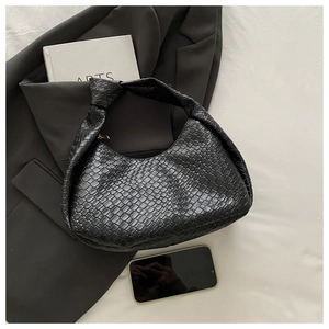 Detail of black woven leather hobo bag featuring a stylish knotted shoulder strap