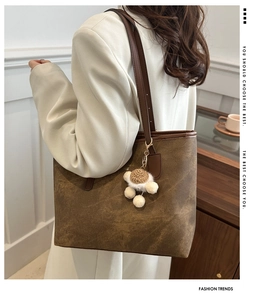 Close-up of retro brown tote bag texture with a cute turtle plush keychain detail