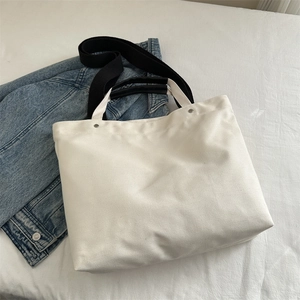 Large off-white canvas tote bag with black strap and handles for daily commute