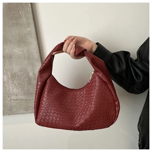 Close-up of burgundy croc-embossed hobo bag with distinctive knot detail on handle