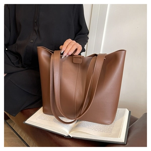 Détail du sac cabas marron en cuir avec fermeture à boucle et fines bandoulières
