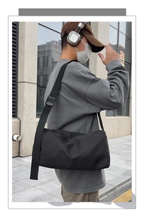 Détail du sac bandoulière noir en nylon minimaliste avec sangle textile large réglable