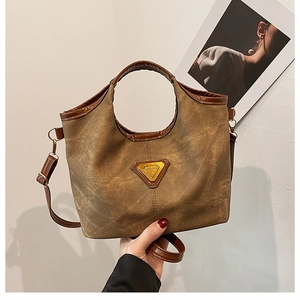 Dettaglio della borsa tote vintage in tela con finiture in pelle e logo metallico