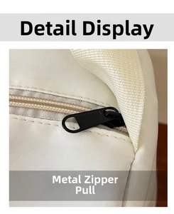Détail de la fermeture éclair en métal noir mat sur un sac fourre-tout en nylon blanc