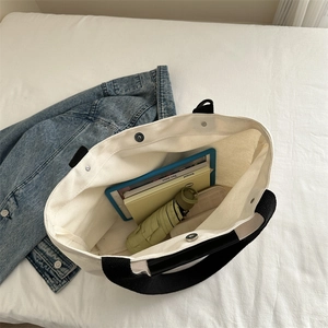 Large white canvas tote bag with black handles showing spacious interior for tablets