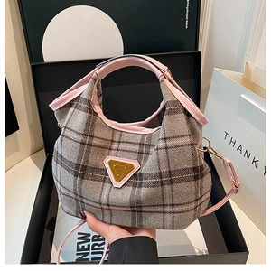 Dettaglio borsa a quadri grigi con finiture in pelle rosa e logo triangolare dorato