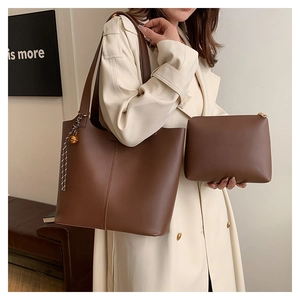 Détail de l'ensemble cabas en cuir marron foncé avec pochette assortie à l'épaule