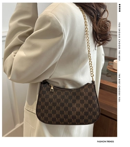 Detail of vintage brown shoulder bag with monogram print and golden chain strap