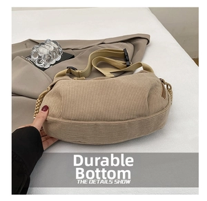 Detail of the corduroy crossbody bag showing the reinforced wear-resistant wide base
