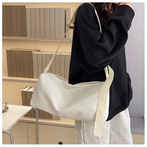 Détail du sac messager en nylon blanc avec large bandoulière dans un décor lifestyle