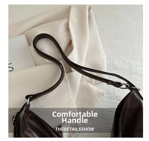 Close-up of soft brown leather handbag showing sewing details and metal ring connector