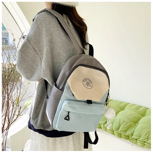Girl's backpack in blue, beige, and grey tricolor design shown on a model's back