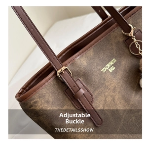 Detail of adjustable metal buckle and leather strap on a vintage brown tote bag