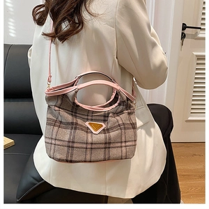 Dettaglio della borsa tote a quadri grigi con rifiniture in pelle rosa e placca in metallo