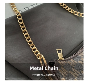 Macro view of light gold chain strap and metal hardware on brown monogram shoulder bag