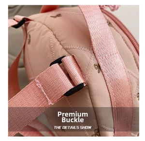 Detail of pink quilted shoulder bag with butterfly embroidery and adjustable strap
