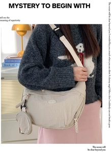 Detail of nylon crossbody bag with a round coin purse and metal brand logo