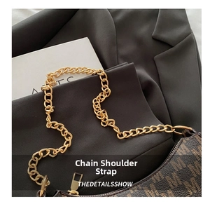 Close-up of golden chunky chain strap on vintage brown monogram crescent shoulder bag