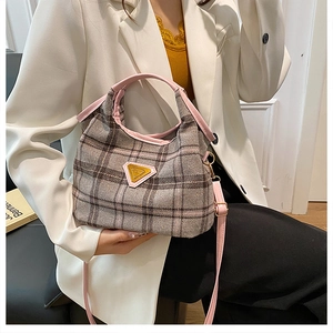 Dettaglio della borsa tote in tweed con finiture rosa e tracolla su una modella