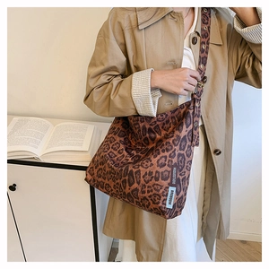 Detail of leopard print faux suede tote bag featuring a branded fabric side label