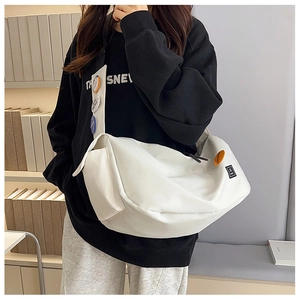 Detail of white large-capacity nylon messenger bag with adjustable strap and badges